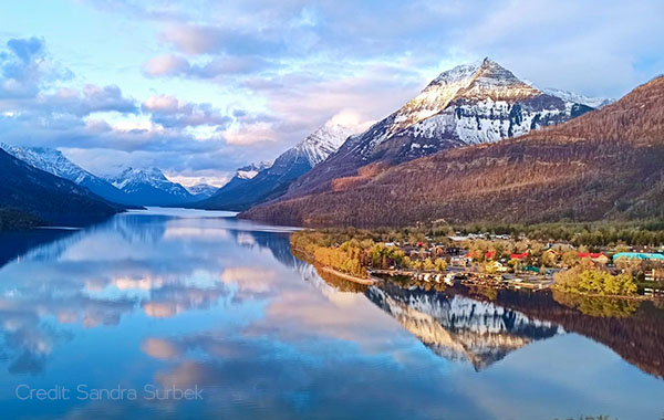 An image overlooking Waterton Lake and the Waterton townsite at dawn.